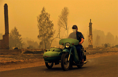A Russian rides a motorcycle in the village of Kriusha...